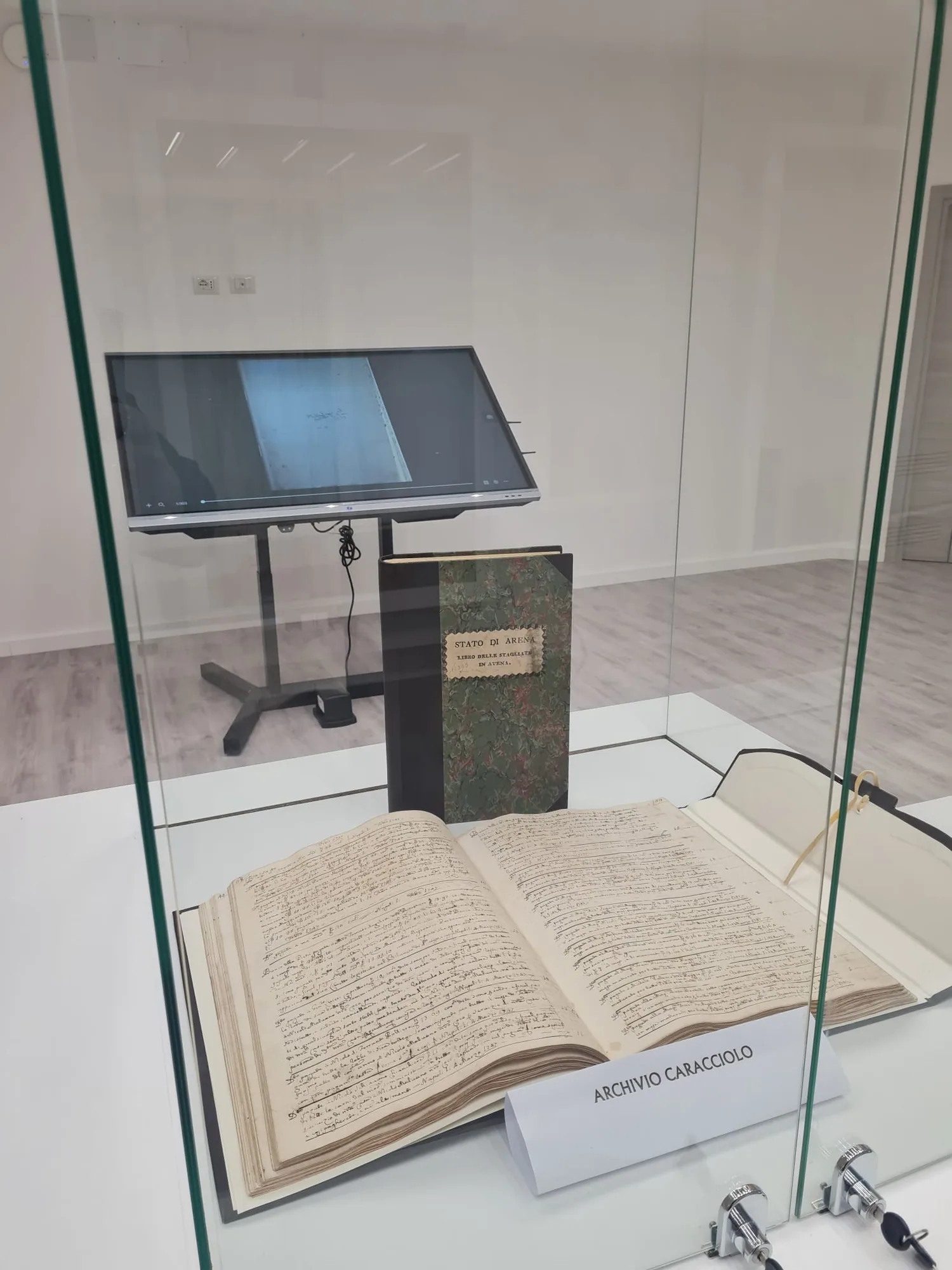 Libro antico dell'Archivio Caracciolo in teca, con il touch screen per sfogliarlo